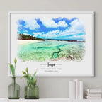 Watercolor-style portrait of a turquoise tropical shoreline, framed in white above a shelf with books and green vases