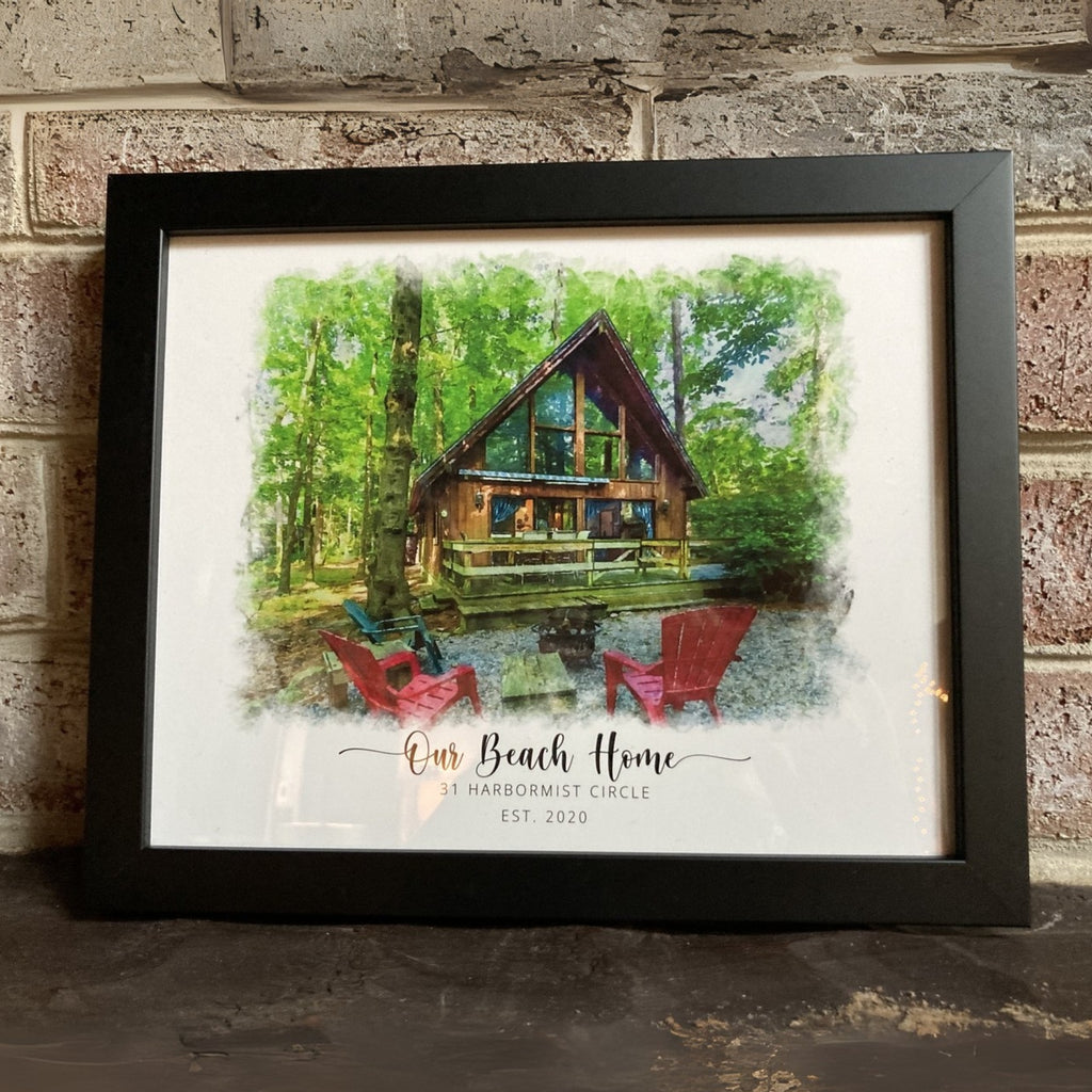 Black-framed watercolor-style portrait of a wooden cabin with red chairs in woods, titled 'Our Beach Home', by a brick wall