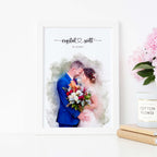 Watercolor-style portrait of a couple with a bouquet, in a white frame beside peonies, their names and a date above