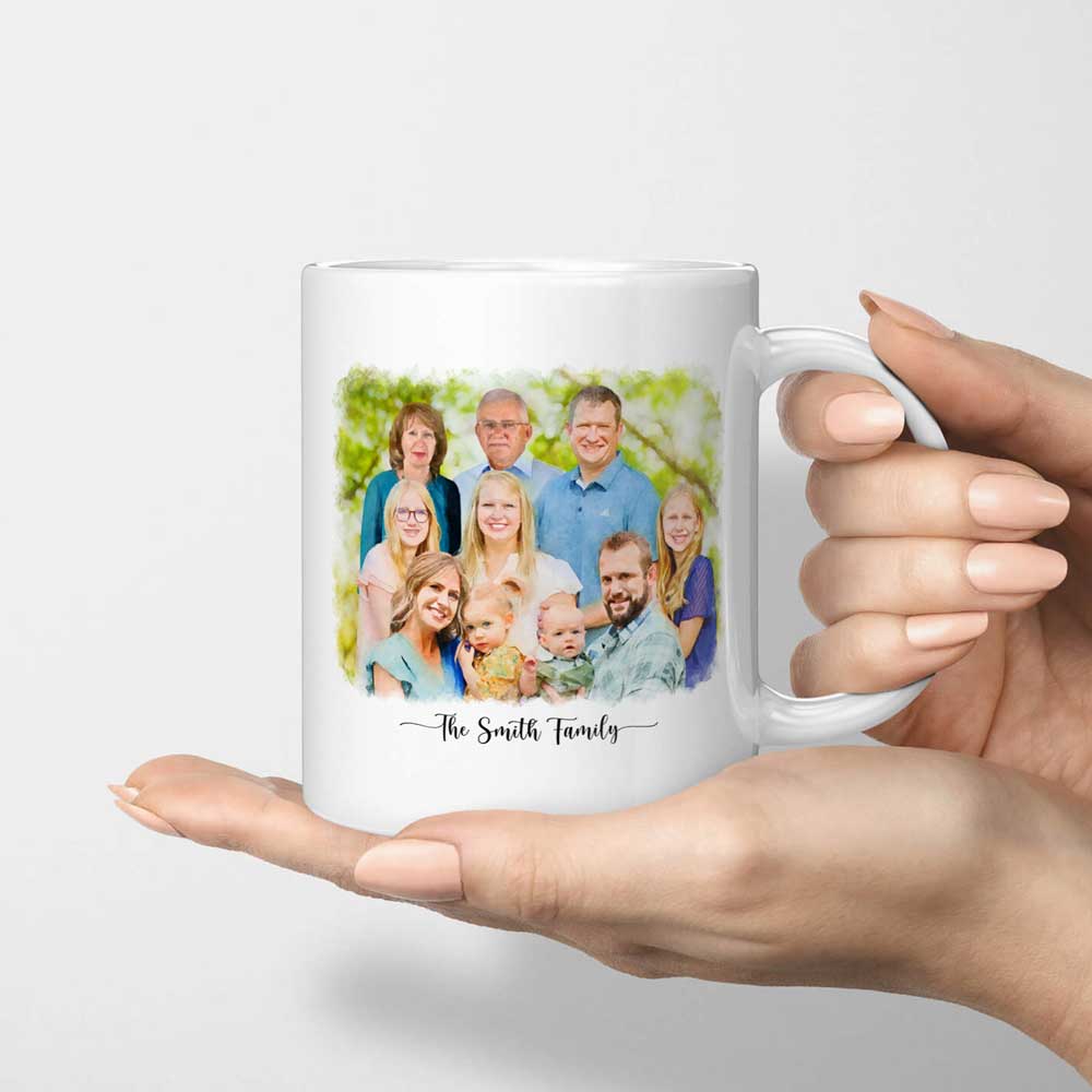 White mug printed with a watercolor-style portrait of a large family and 'The Smith Family', held in an open hand